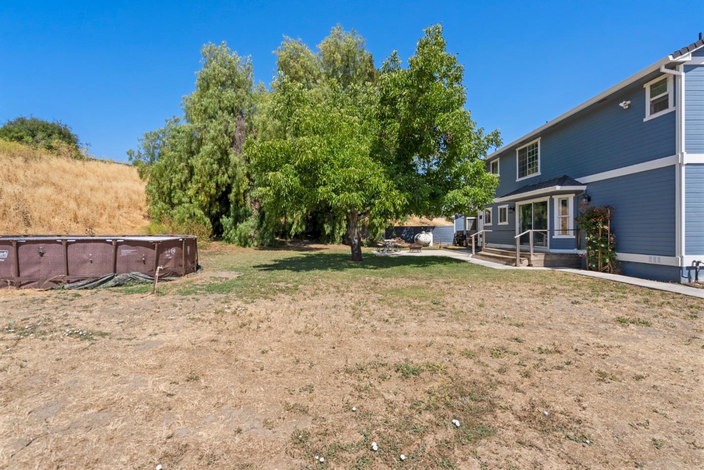 695 Hospital Road Hollister, CA 95023 - Photo 49 of 61 a backyard of a house with large trees and outdoor seating