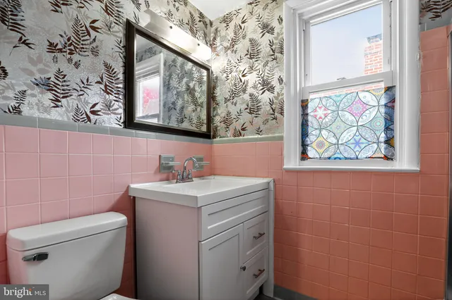 a bathroom with a toilet sink and mirror