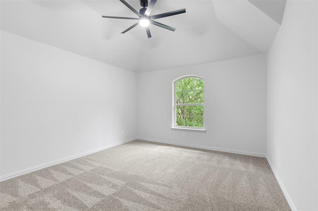 11984 Del Rio Drive Frisco, TX 75035 - Photo 30 of 38 Carpeted spare room featuring lofted ceiling, a ceiling fan, and baseboards