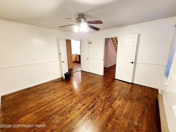 a view of empty room with wooden floor