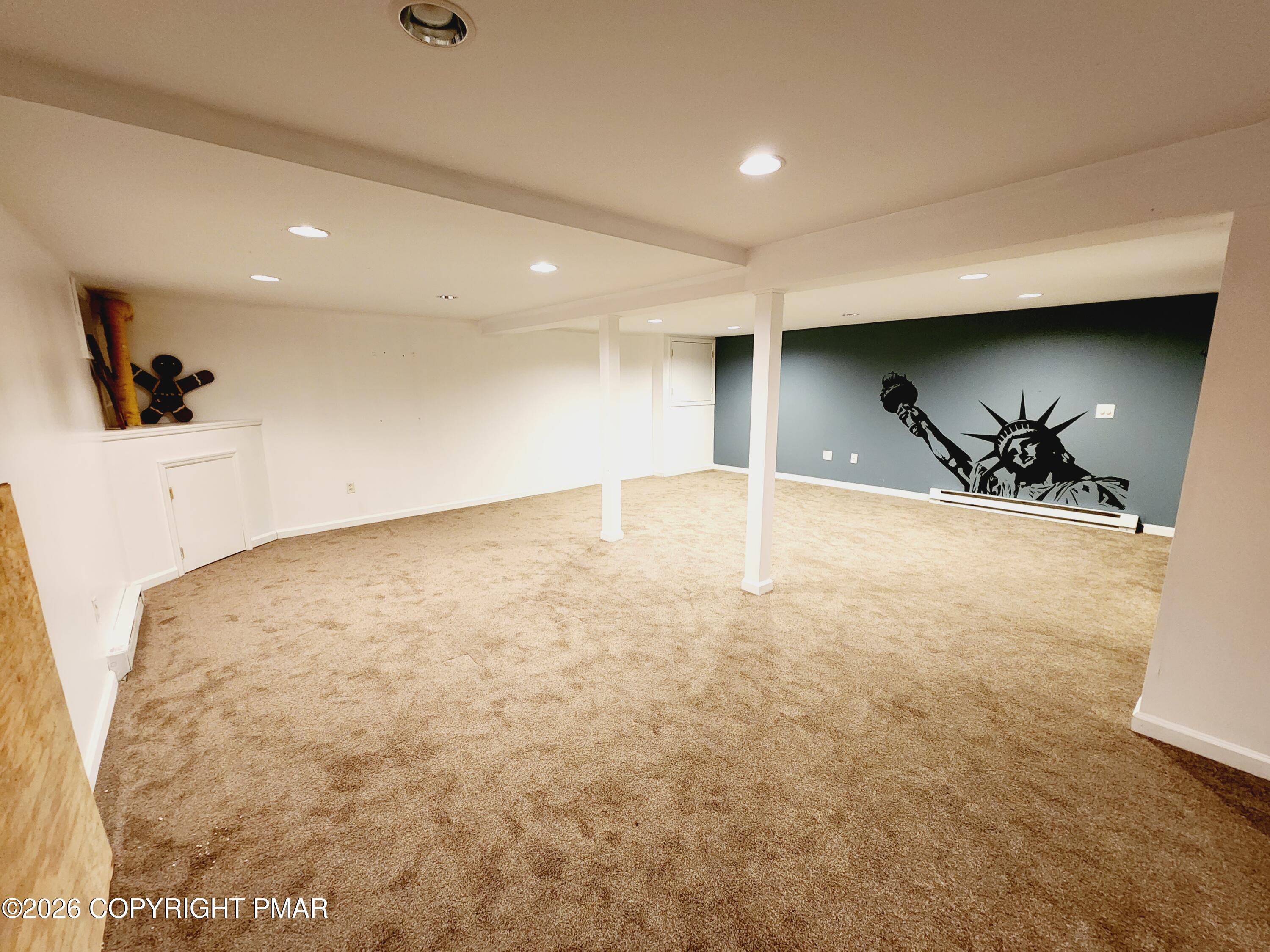 239 Rock Ridge Road Mount Pocono, PA 18344 - Photo 28 of 33 an empty room with a projector and wooden floor