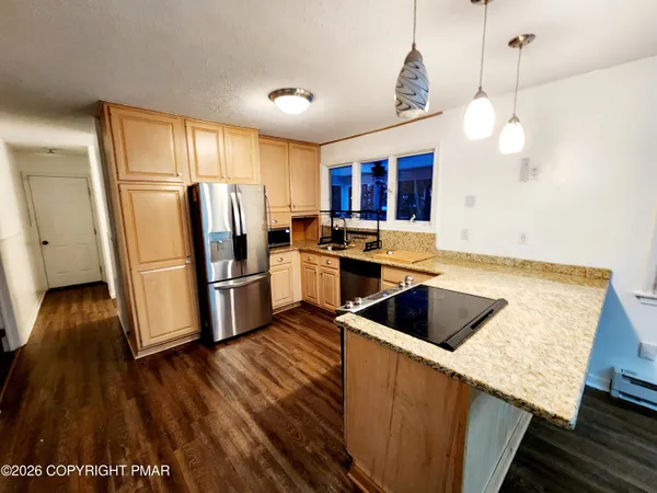 a kitchen with refrigerator cabinets and wooden floor