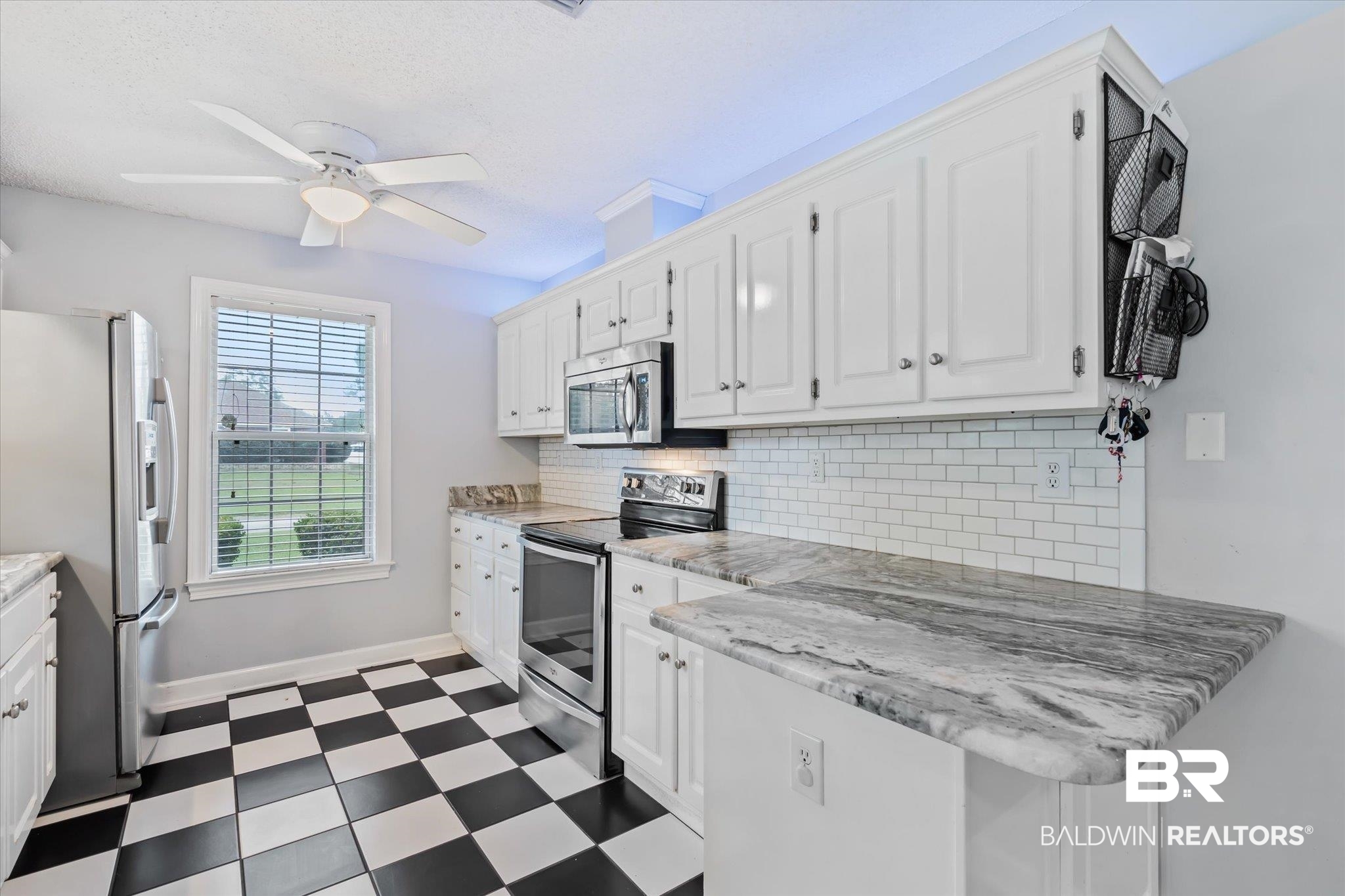 2320 Sequoya Trail Mobile, AL 36695 - Photo 6 of 20 Kitchen featuring appliances with stainless steel finishes, tasteful backsplash, white cabinets, light tile patterned floors, and ceiling fan