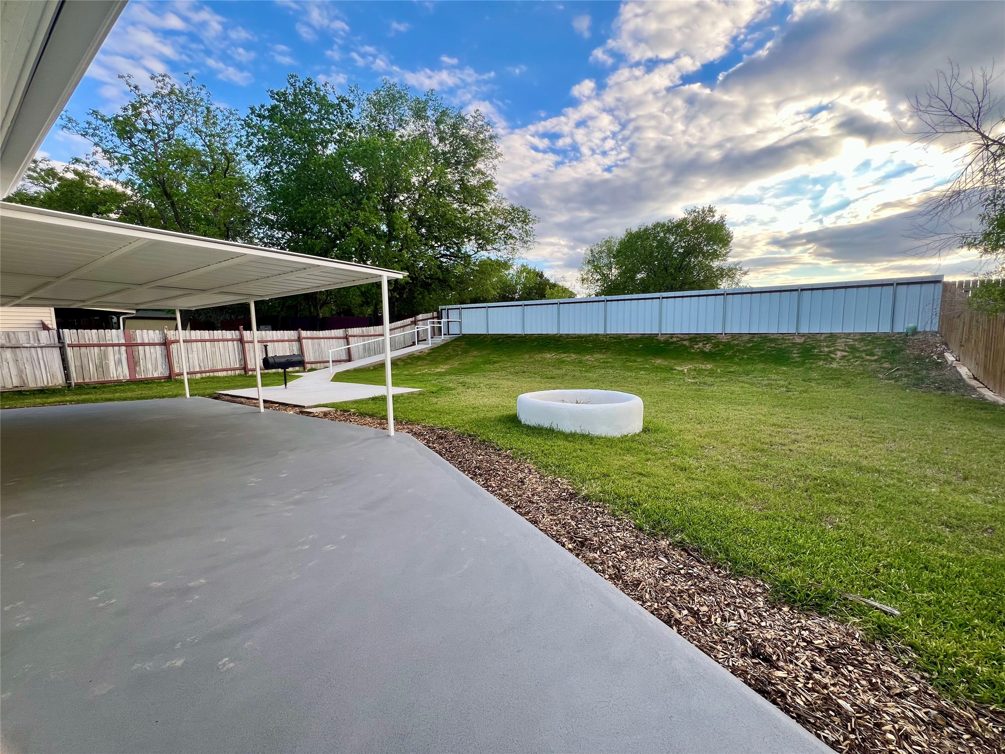 8007 Colony Loop Drive Austin, TX 78724 - Photo 1 of 40 Large backyard with covered patio, open lawn, and built-in fire pit designed for entertaining and everyday outdoor living.