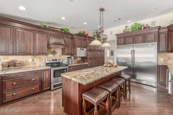 a kitchen with a stove a refrigerator and a wooden cabinets