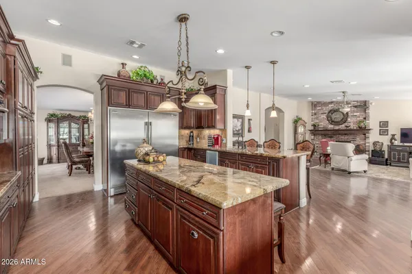 a large kitchen with stainless steel appliances kitchen island granite countertop a large island a stove and a wooden floors