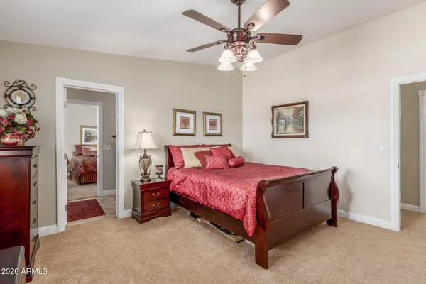 a spacious bedroom with a bed and a chandelier