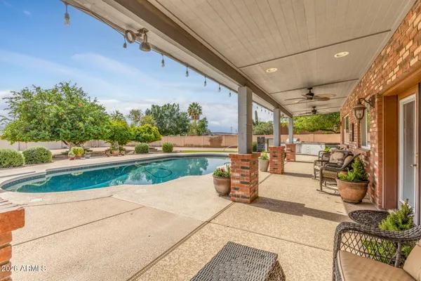 a view of a patio with couches table and chairs and potted plants
