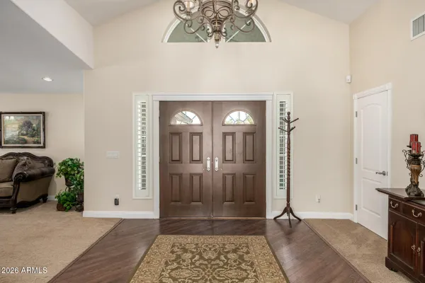 a view of a hallway with wooden floor and a living room