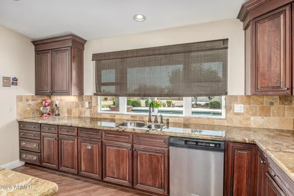 a kitchen with stainless steel appliances granite countertop wooden cabinets and a counter top space