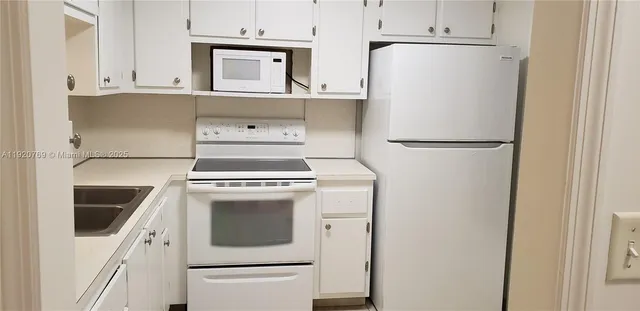 a white refrigerator freezer sitting inside of a kitchen