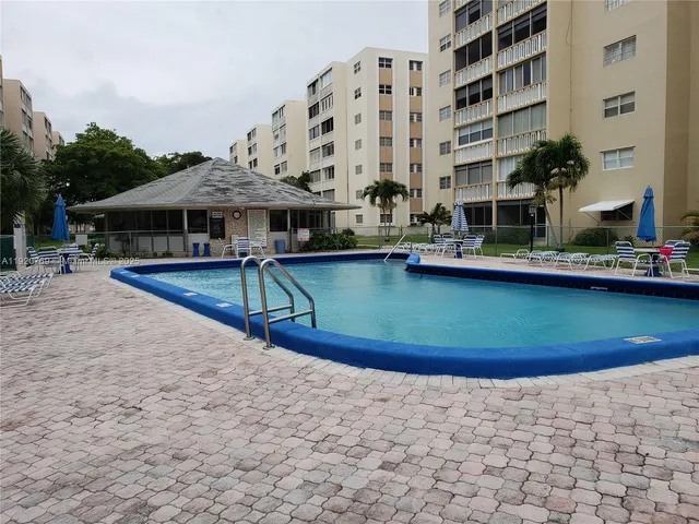a view of a swimming pool with a bench in front of house
