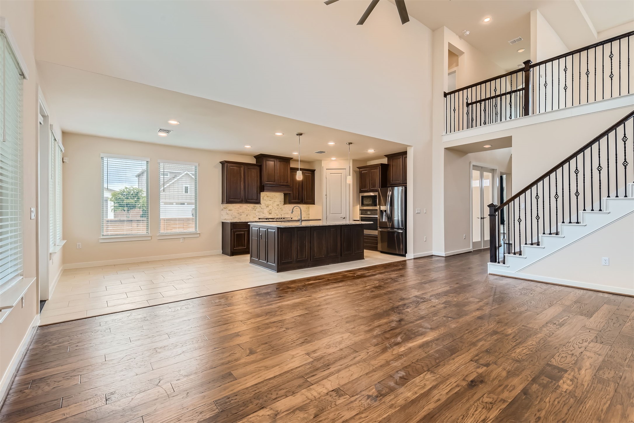 8313 Spire View Austin, TX 78744 - Photo 8 of 33 An open-concept living area features a grand two-story ceiling and rich wood flooring.