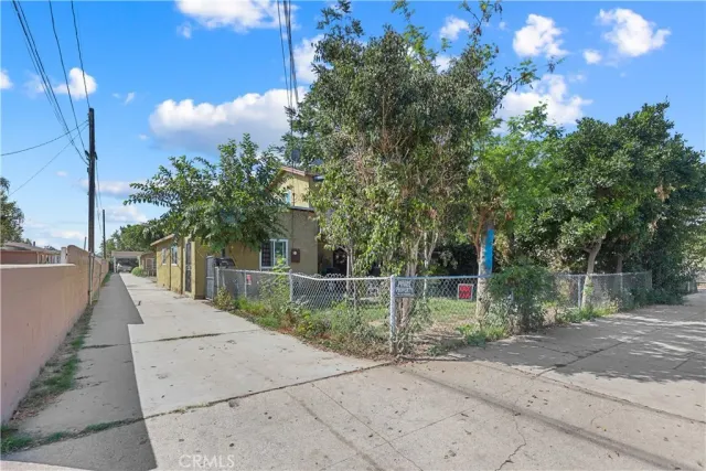 a backyard of a house with table and chairs and potted plants