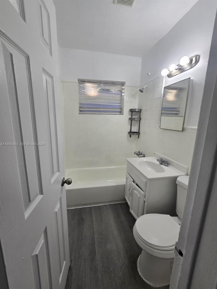 2729 Northwest 47th Street Miami, FL 33142 - Photo 5 of 34 a bathroom with a toilet sink and mirror