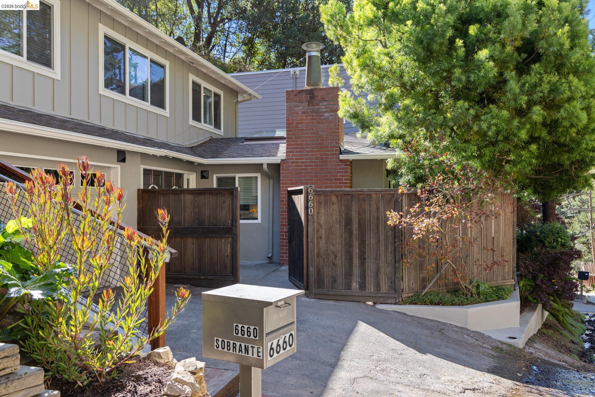 6660 Sobrante Road Oakland, CA 94611 - Photo 44 of 48 Two-story exterior with horizontal siding and multiple windows, featuring a prominent brick chimney