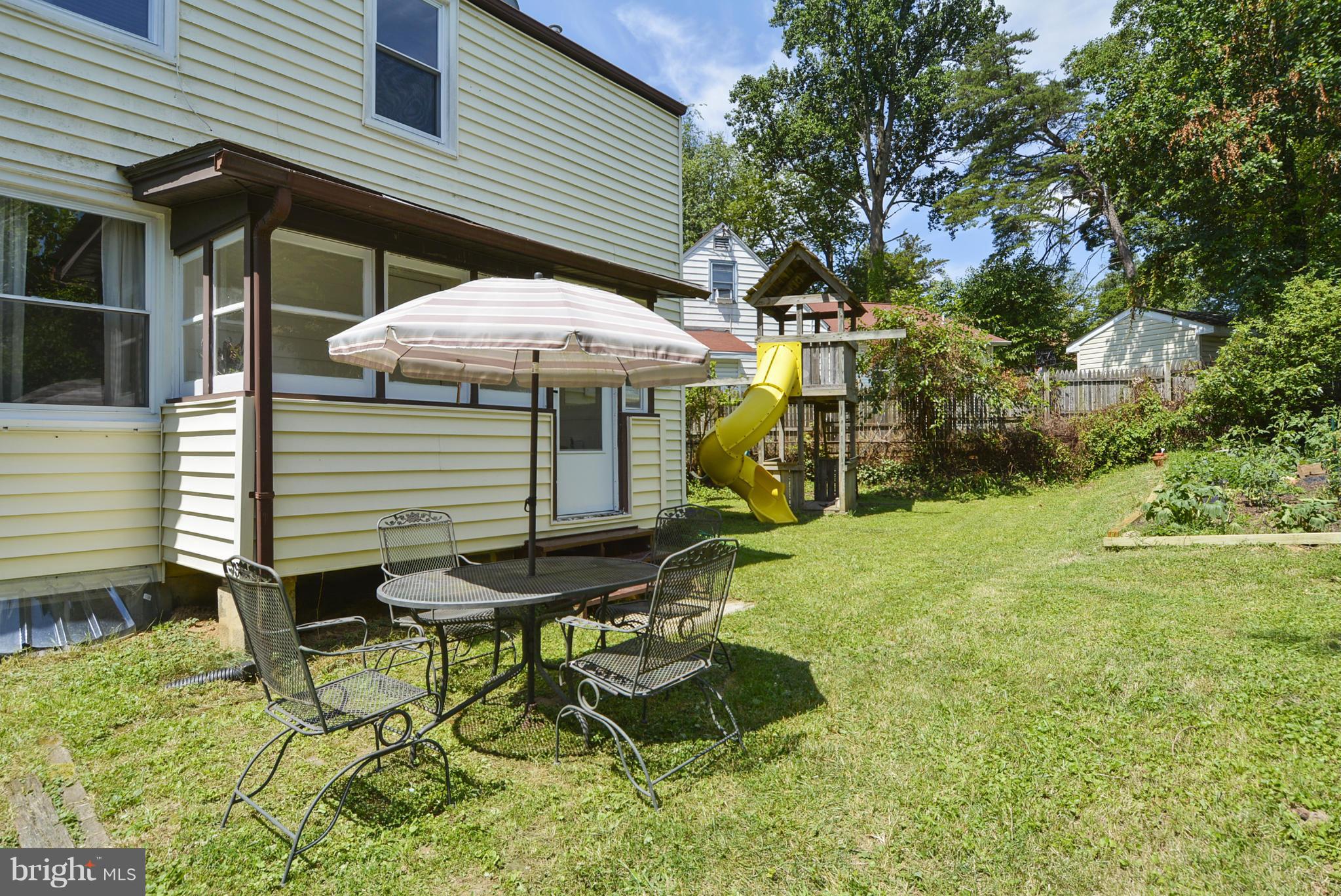2707 Weisman Road Silver Spring, MD 20902 - Photo 5 of 30 a yellow house with a yard and sitting area