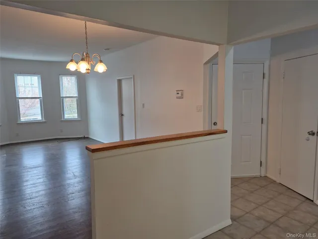 a view of a room with wooden floor and chandelier
