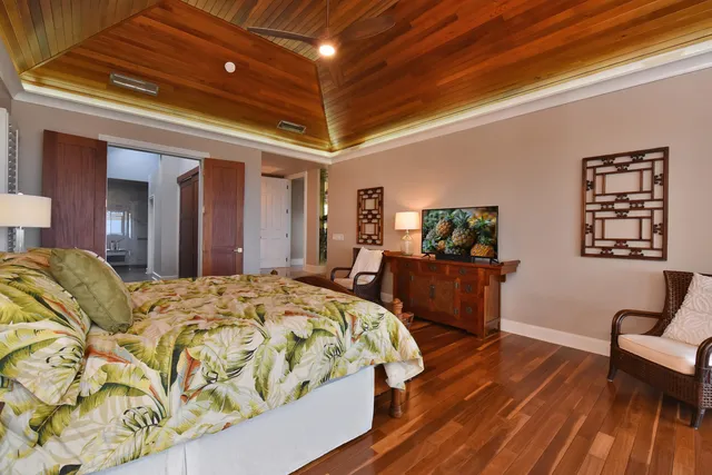 a bed sitting in a spacious bedroom next to a window