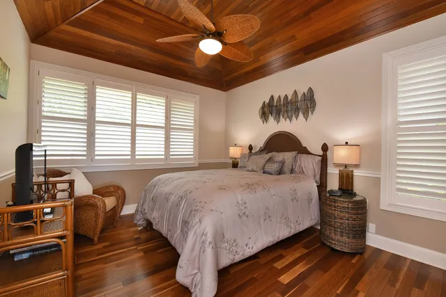 a bed sitting in a spacious bedroom next to a window