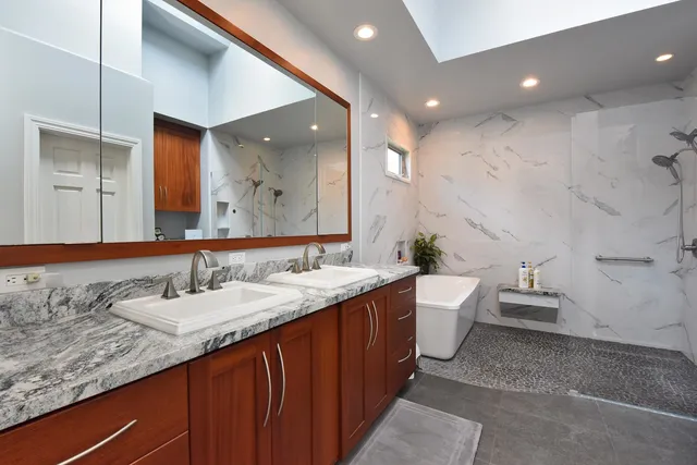 a bathroom with a granite countertop sink and a mirror