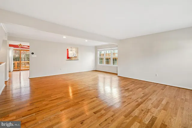 a kitchen with stainless steel appliances kitchen island granite countertop a stove a refrigerator a dining table and chairs with wooden floor