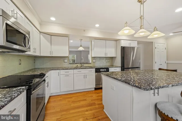 a bathroom with a granite countertop sink and a window