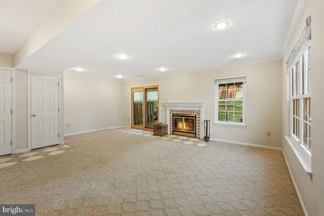 a view of an empty room with a fireplace and a window