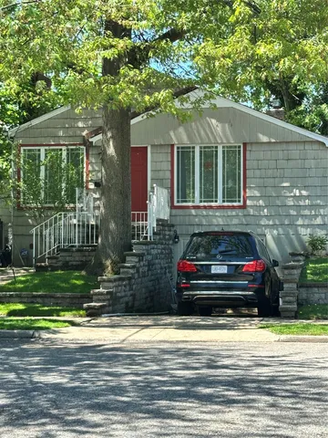 a view of a house that has a bed and a large tree