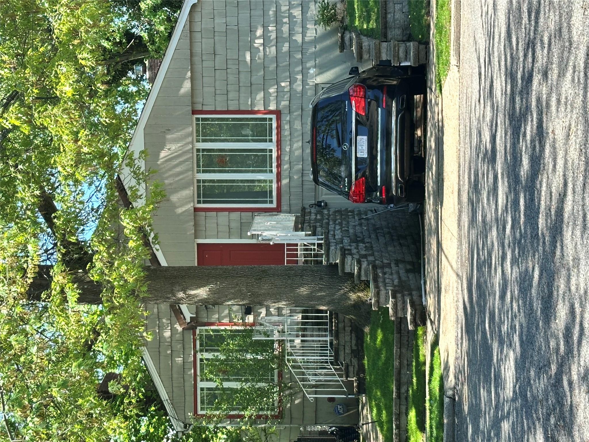 a view of a house that has a bed and a large tree