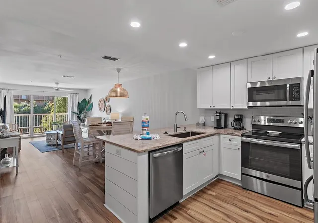 a kitchen with granite countertop a stove and a white cabinets