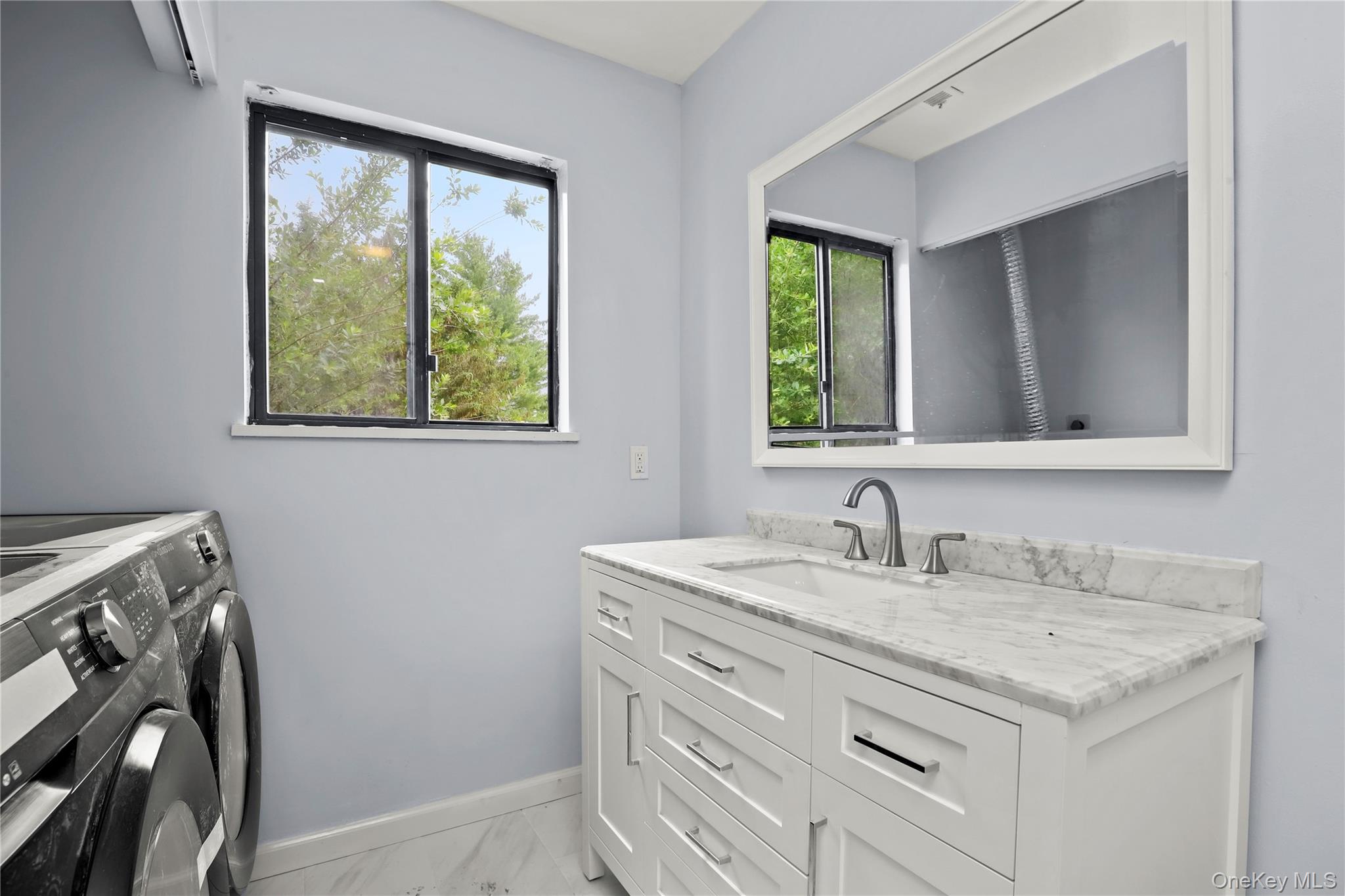 41 Rambling Brook Road Chappaqua, NY 10514 - Photo 24 of 29 Laundry room with washer and dryer, baseboards, light marble finish floors, and plenty of natural light