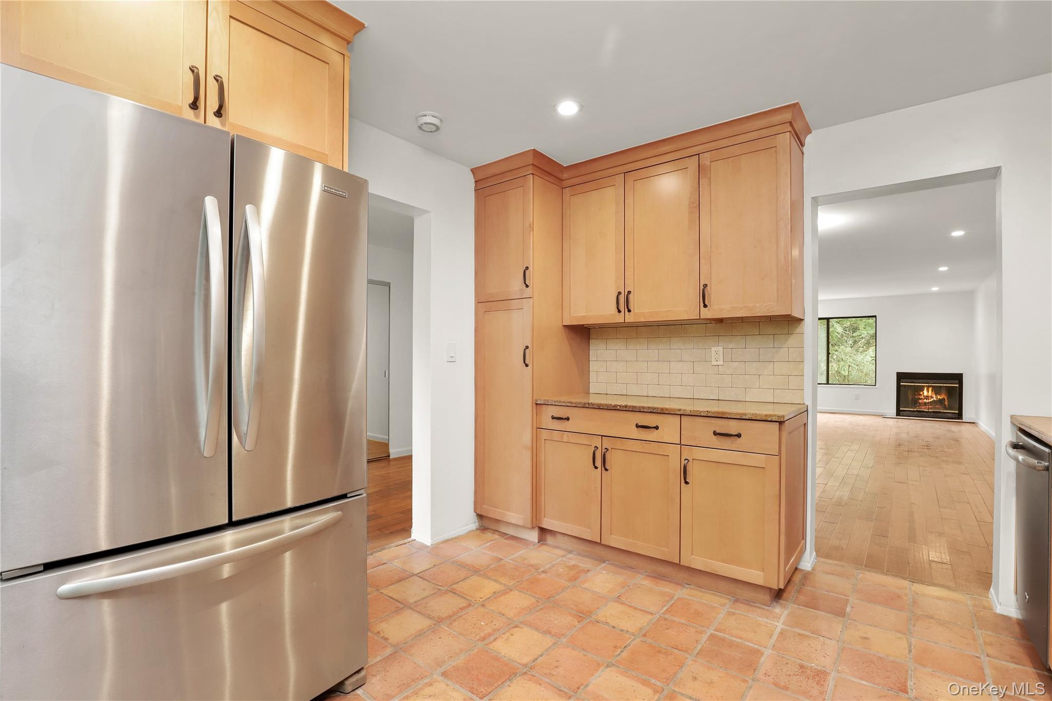 41 Rambling Brook Road Chappaqua, NY 10514 - Photo 5 of 29 Kitchen with freestanding refrigerator, light brown cabinetry, tasteful backsplash, recessed lighting, and a glass covered fireplace