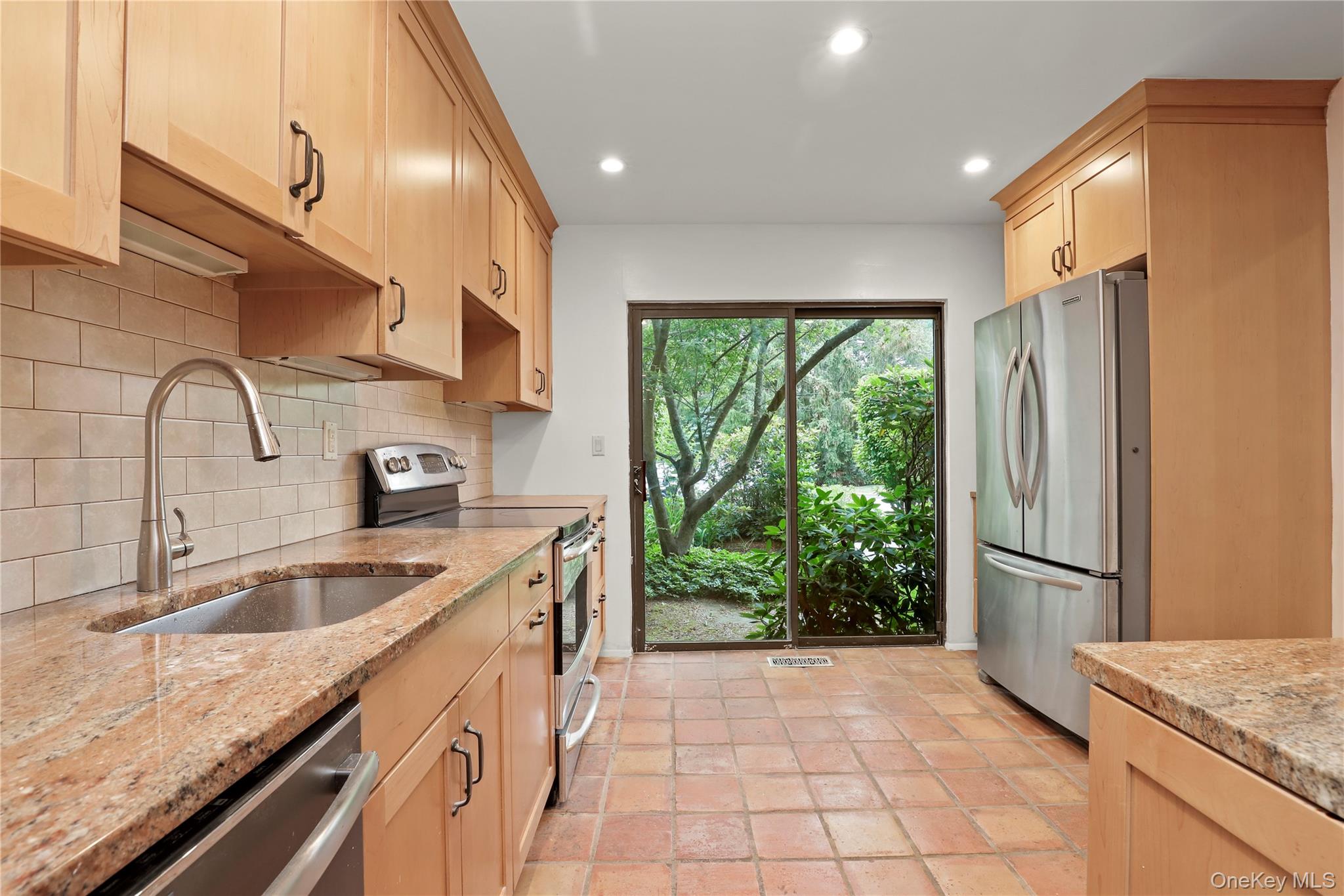 41 Rambling Brook Road Chappaqua, NY 10514 - Photo 7 of 29 Kitchen with appliances with stainless steel finishes, a sink, decorative backsplash, light brown cabinetry, and light stone countertops