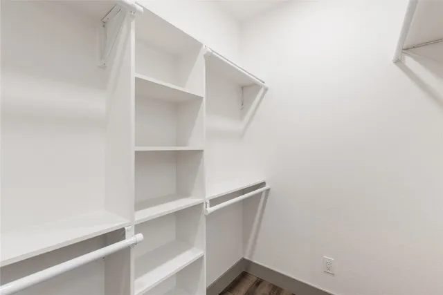a view of empty room with wooden floor and window