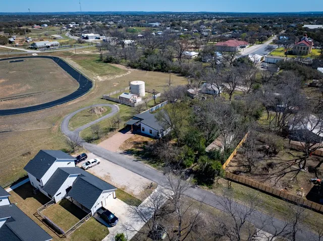 an aerial view of a house with a swimming pool and lake view