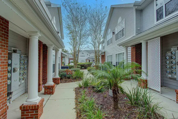 a view of a brick house with plants and walls