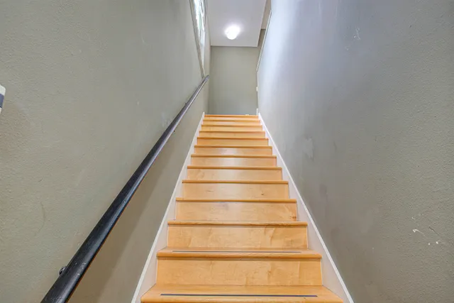 an empty room with wooden floor chandelier and windows