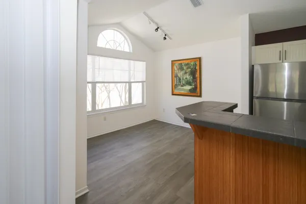 a kitchen with granite countertop white cabinets and black appliances