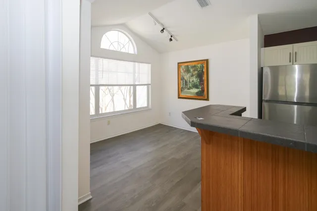 a kitchen with granite countertop white cabinets and black appliances