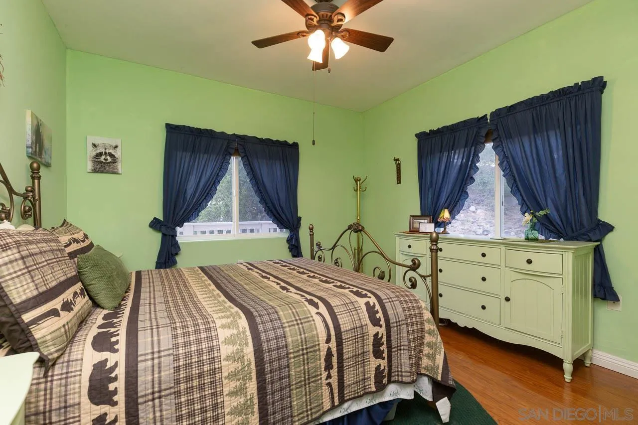 8048 High Hill Road Julian, CA 92036 - Photo 13 of 30 a bed sitting in a bedroom next to a wooden floor