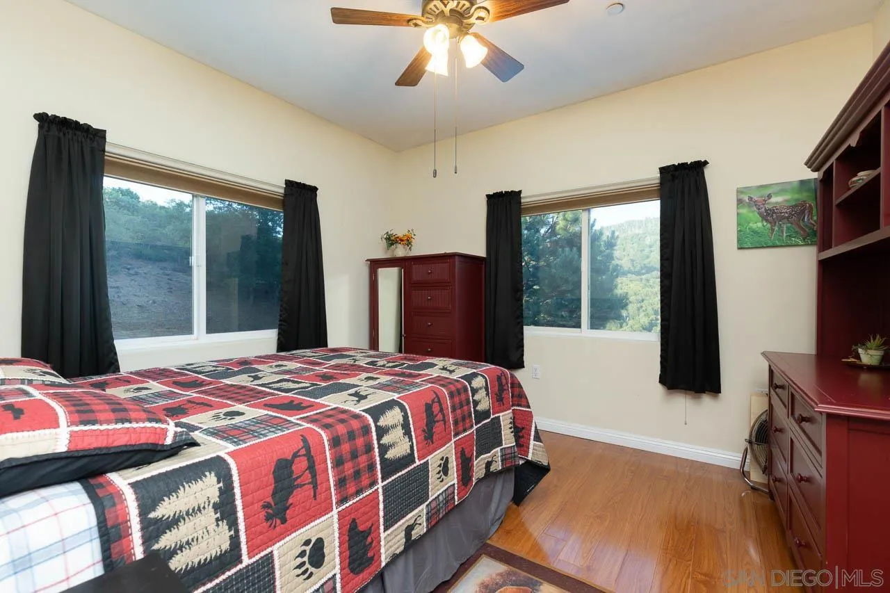 8048 High Hill Road Julian, CA 92036 - Photo 17 of 30 a bedroom with a bed and a flat tv screen next to a window