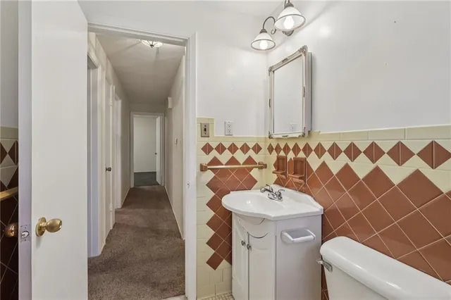 a bathroom with a toilet a sink and mirror