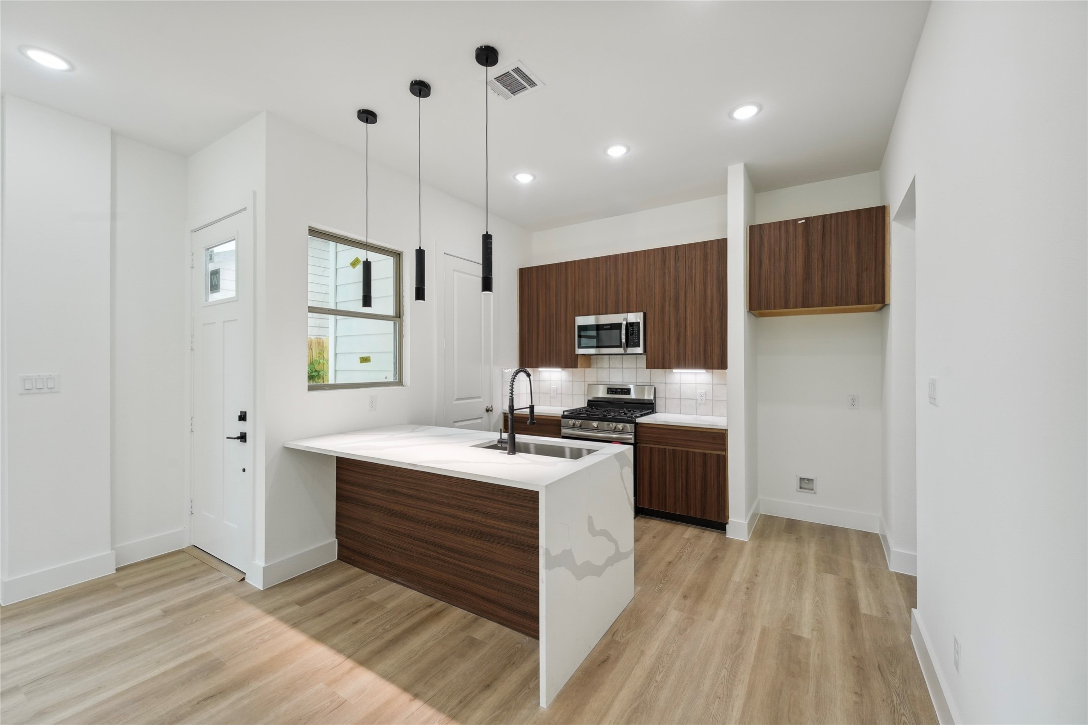 7416 Maxroy Street Houston, TX 77088 - Photo 3 of 41 a kitchen with kitchen island a sink stainless steel appliances and cabinets