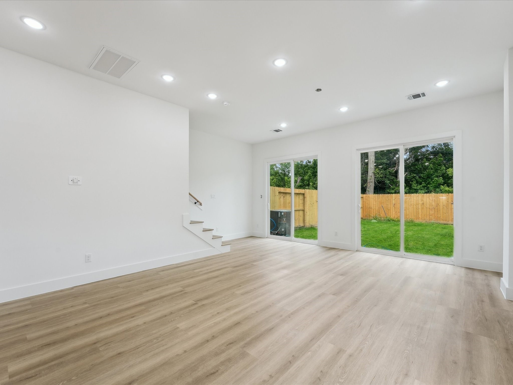 7416 Maxroy Street Houston, TX 77088 - Photo 7 of 41 a view of an empty room with wooden floor and a window