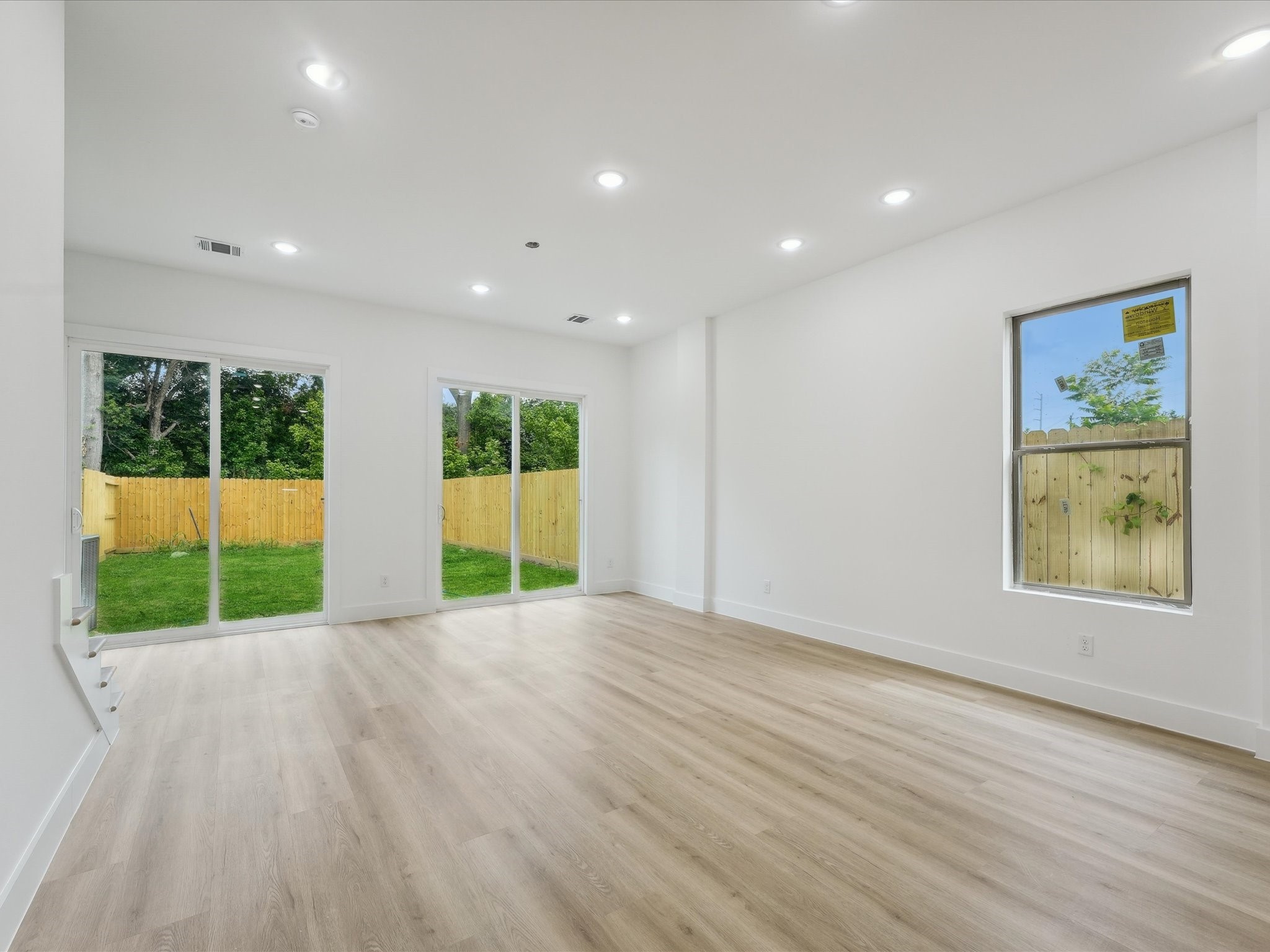 7416 Maxroy Street Houston, TX 77088 - Photo 8 of 41 a view of an empty room with wooden floor and a window
