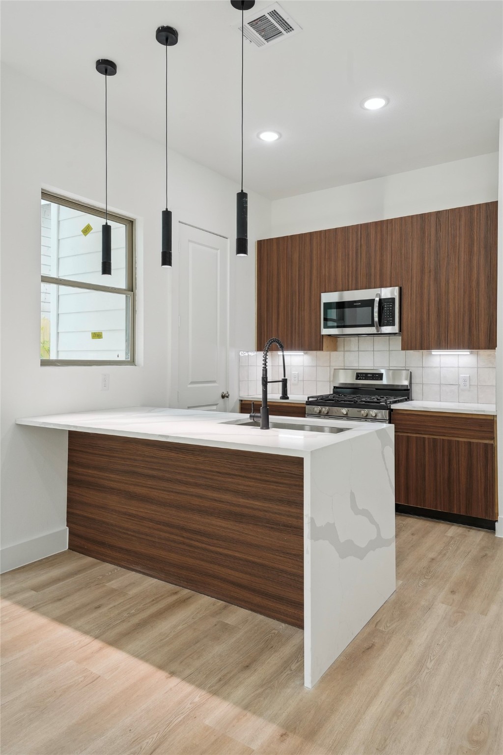 7416 Maxroy Street Houston, TX 77088 - Photo 9 of 41 a large kitchen with kitchen island a sink stainless steel appliances and cabinets