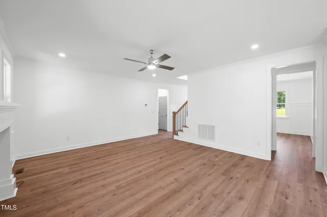 a large kitchen with kitchen island a sink dishwasher a stove and a refrigerator with wooden floor