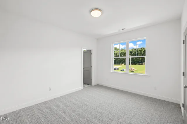 an empty room with windows and ceiling fan