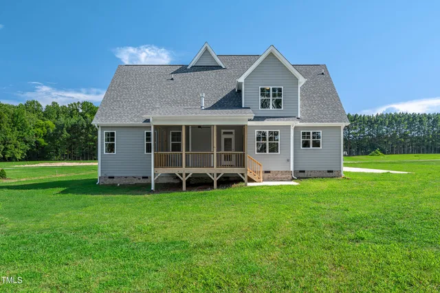 a view of a house with a yard and sitting area